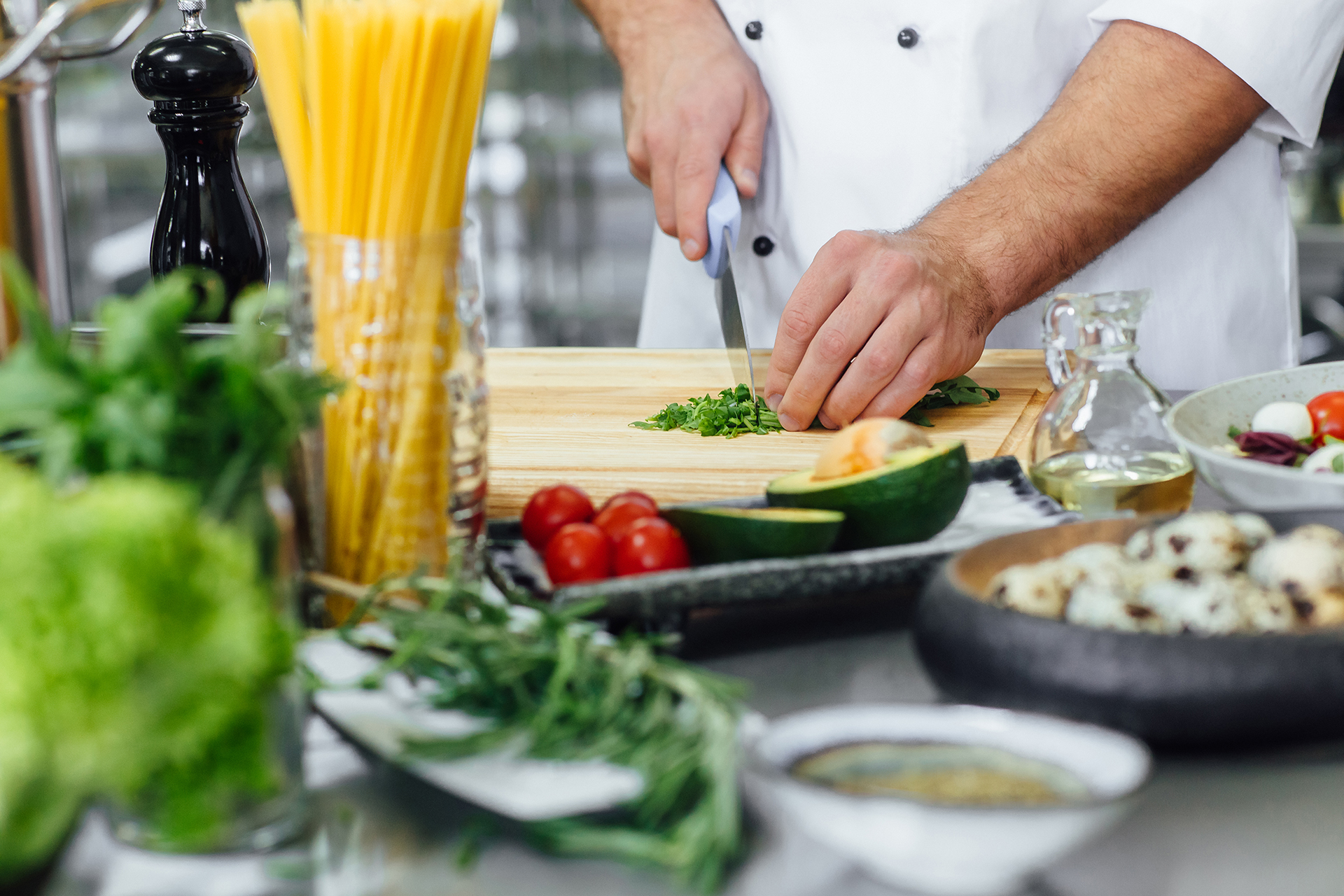 Chef cutting the vegetable and preparing salade. Only hands. Finally dish dressing. Close up photo.